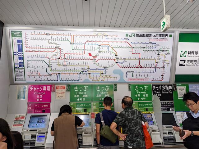 A row of vending machines under a map of the Tokyo rail system.