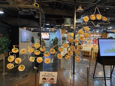 Outline map of japan with different ramen bowls affixed to different areas. In front is a touchscreen which visitors can use to explore the different ramen varieties from each region of the country.