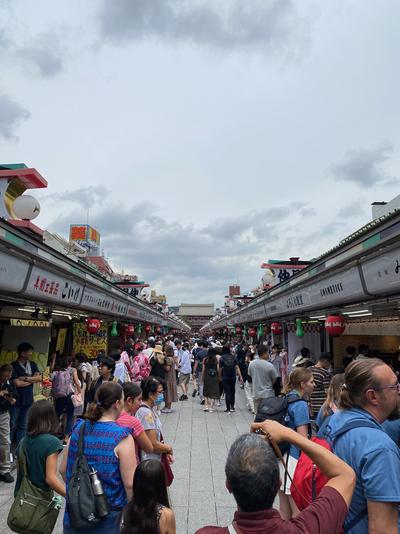 View of the Nakamise Shopping Street leading to Sensōji temple in Asakusa. Tourists shop at various stalls along the street.