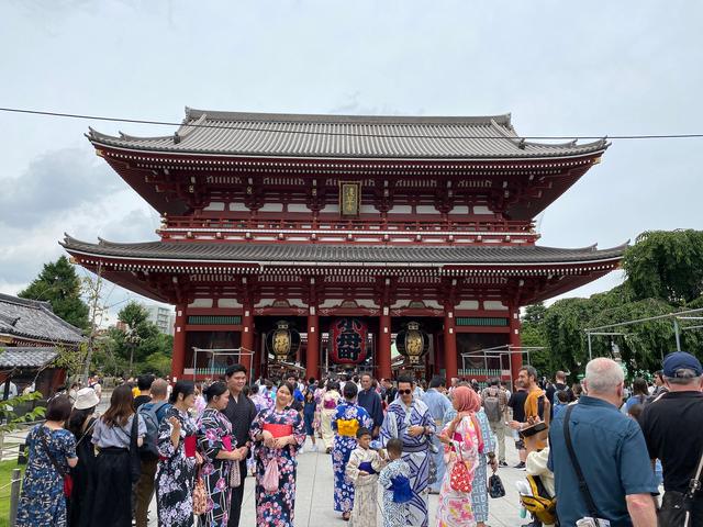 Tourists in colorful kimonos in front of Hōzōmon temple.