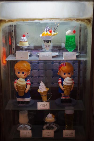 A glass case holding models of different dessert options.