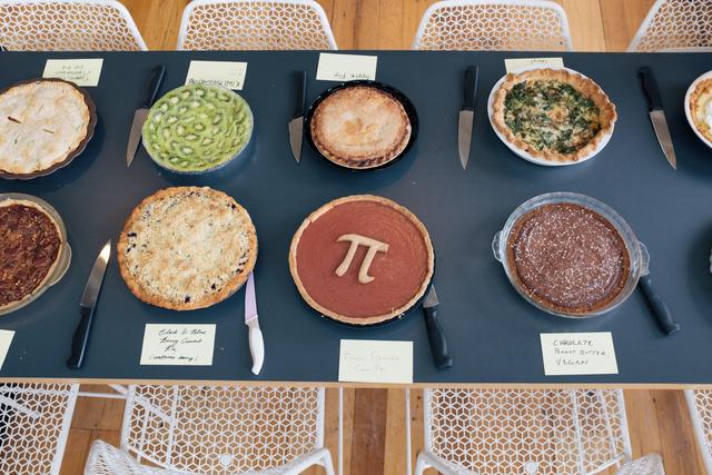 Various pies lined up on a table.
