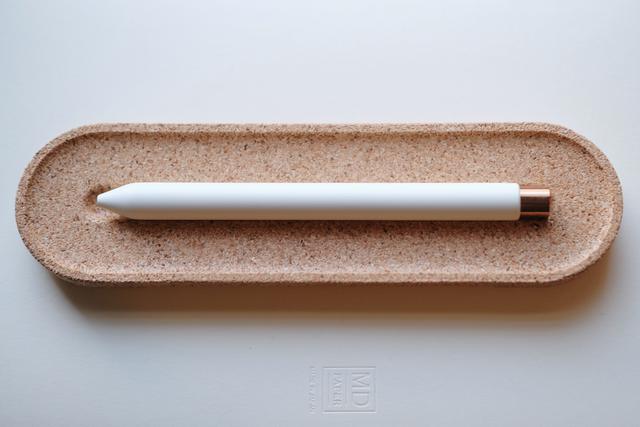 View of white/copper pen in a cork holder.