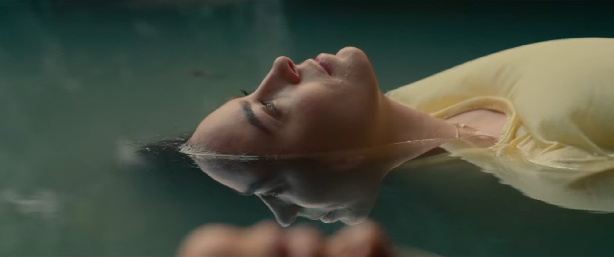 The layers here! Blurred out foreground, touching a reflection from the in-focus background, like an upside-down kiss. Image © Netflix. Layered shot with reflection in the water seeming to touch the foreground character’s face.