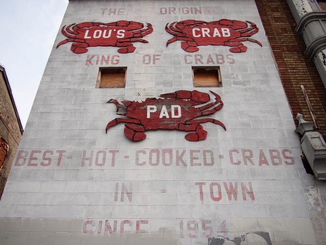 Sign for Lou’s Crab Pad on the side of a building.