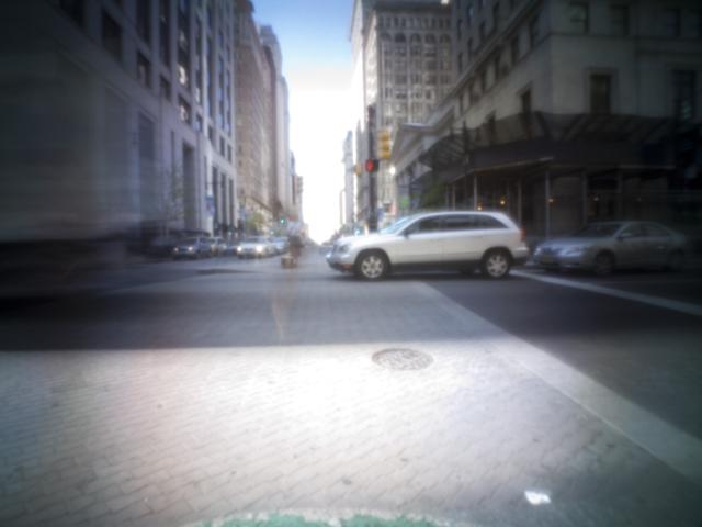 Pinhole photo of a street intersection.