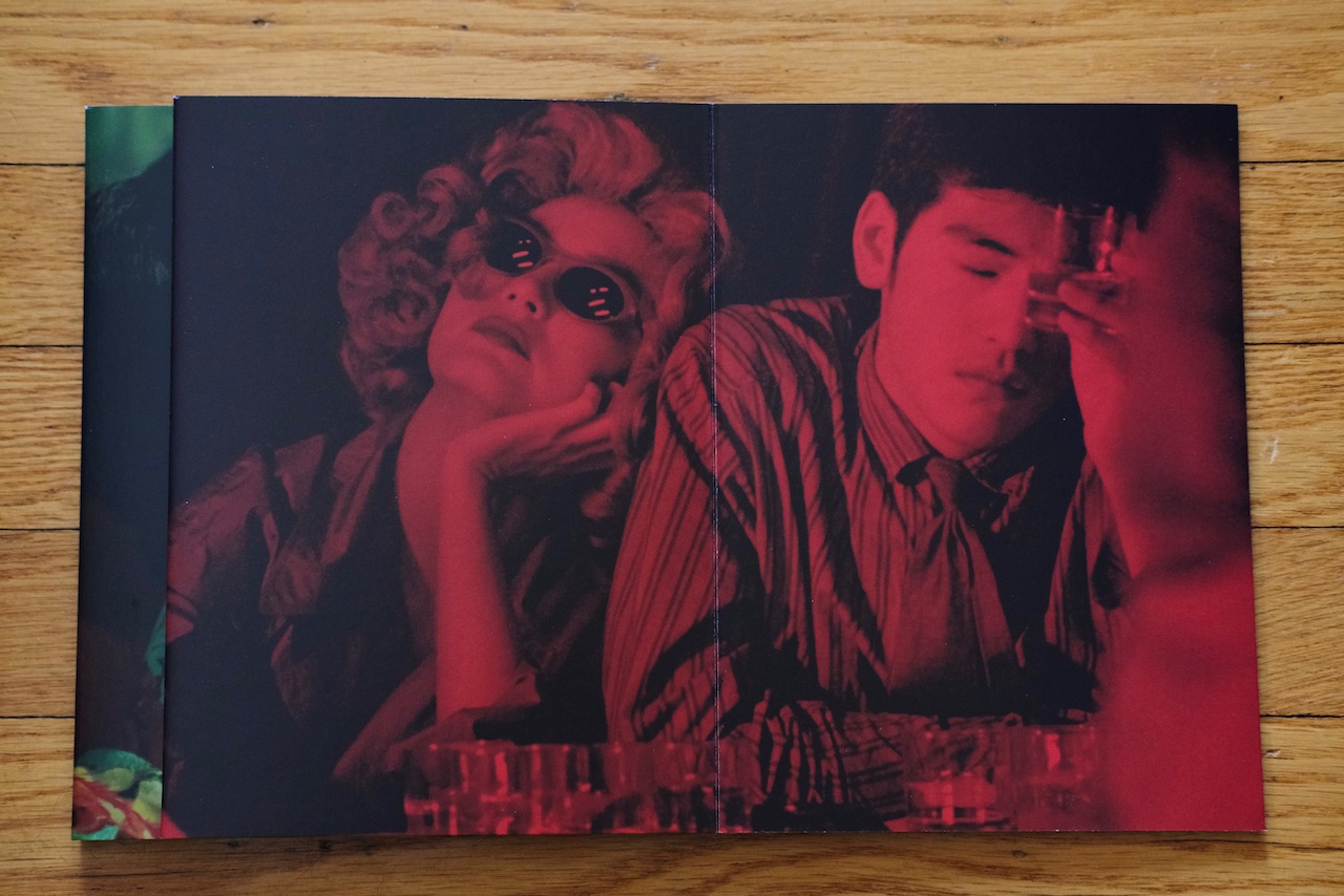 That *red*! A man an woman lean against each other in a bar lit with red.